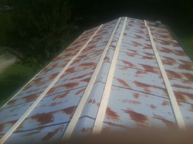 Rusted metal roof panels with new wood purlins before replacement — Storm Damage Roof Repair in Round Mountain by Roofing Brothers