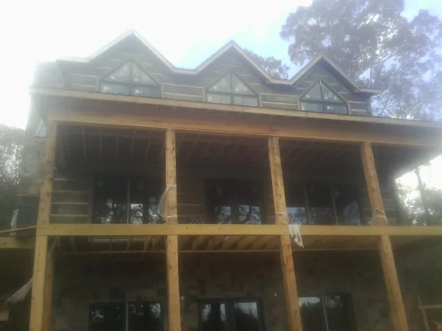 Dormers and porch framing on a large log home under construction — Roof Coating work by our crew in Round Mountain