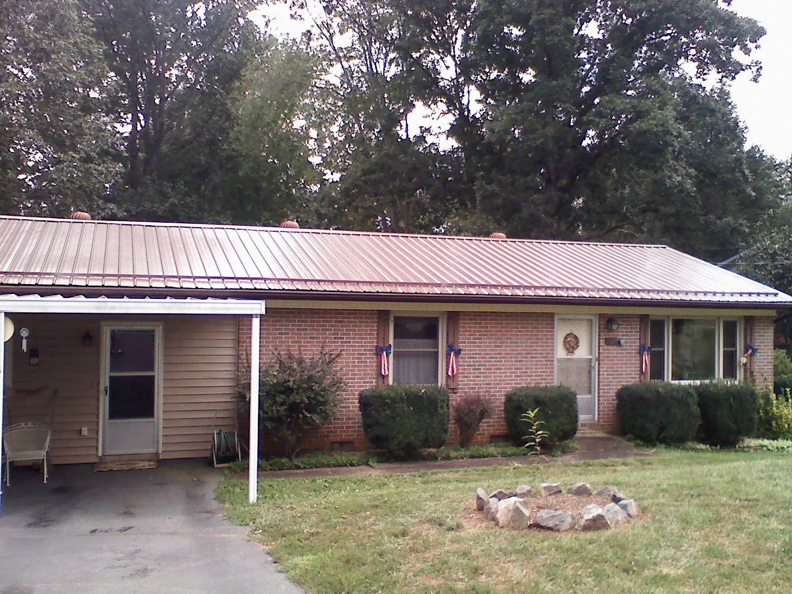 Bronze metal roof and carport on a brick ranch home — Roof Repair work by our crew in Round Mountain